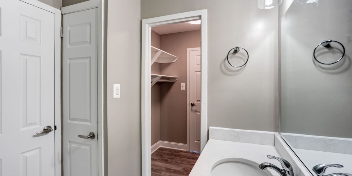 Bathroom area with large mirror and closet space at The Cambridge Apartments in Washington, District of Columbia
