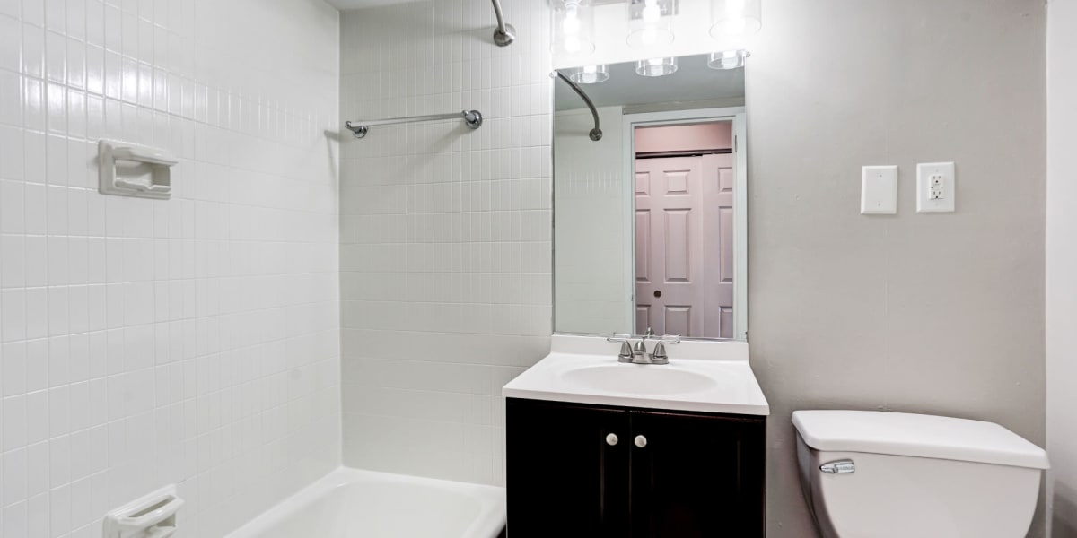 Spacious bathroom with vanity mirror at The Cambridge Apartments in Washington, District of Columbia