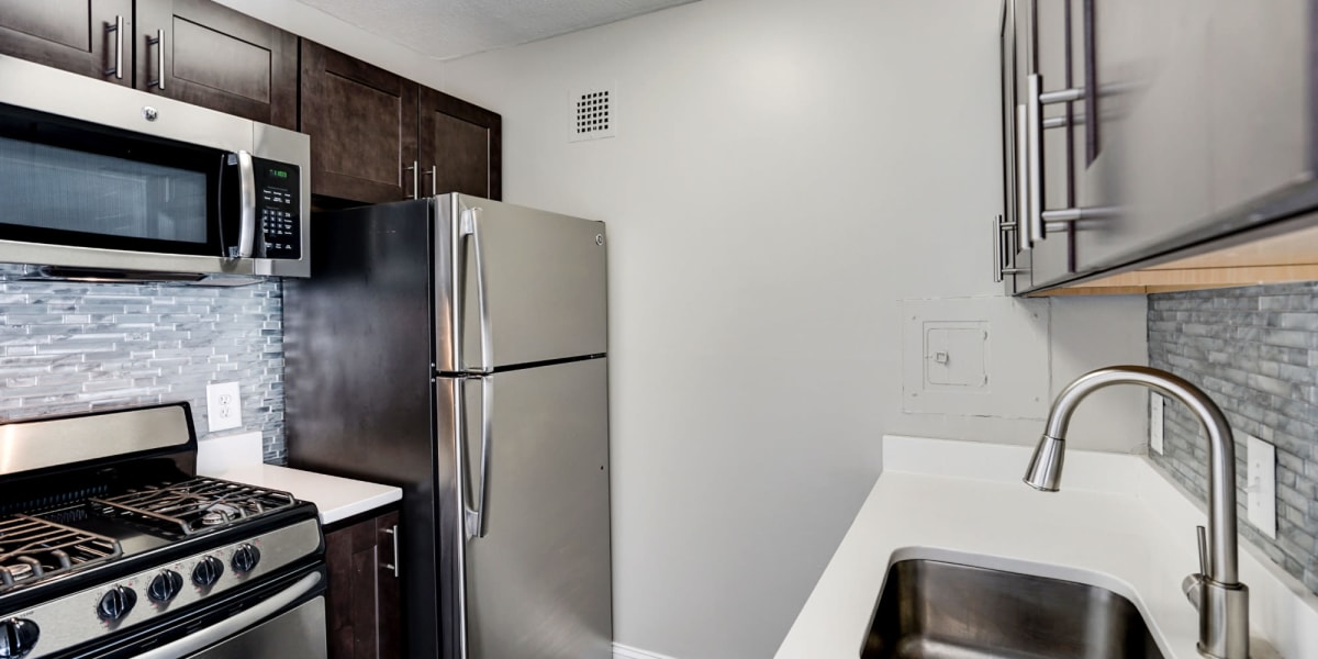 Stainless steal appliances with dark wood cabinets at The Cambridge Apartments in Washington, District of Columbia