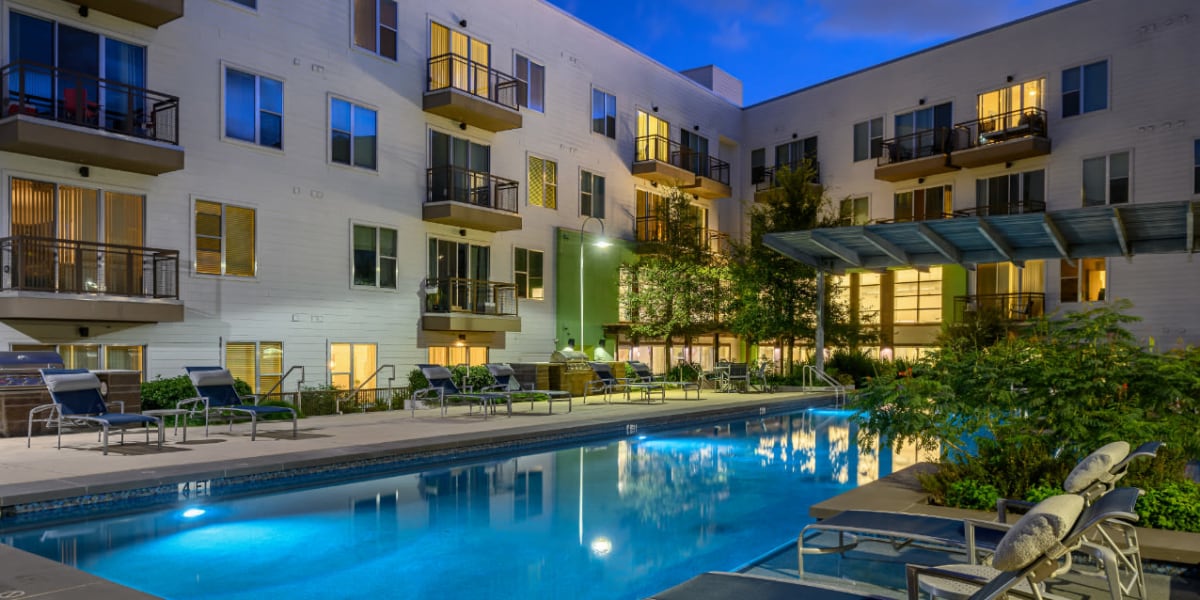 Sparkling pool surrounded by lounge chairs at sunset at Sabina in Austin, Texas