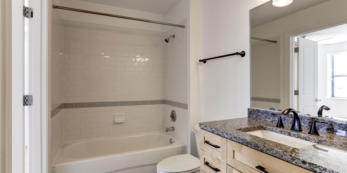 Large bath and shower combo in the bathroom with a huge vanity mirror at 1630 R St NW in Washington, District of Columbia