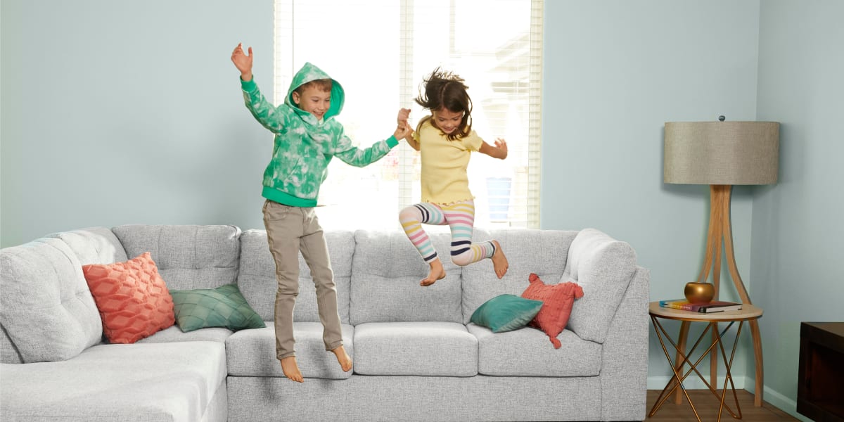 Kids jumping on the new couch at home at BB Living at Murphy Creek in Aurora, Colorado