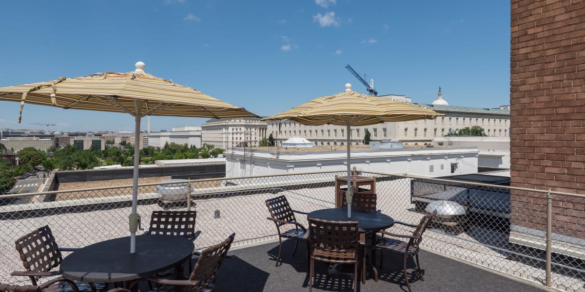 Amazing rooftop patio with lots of chairs and umbrellas at the tables to stay shaded at Hill House in Washington, District of Columbia