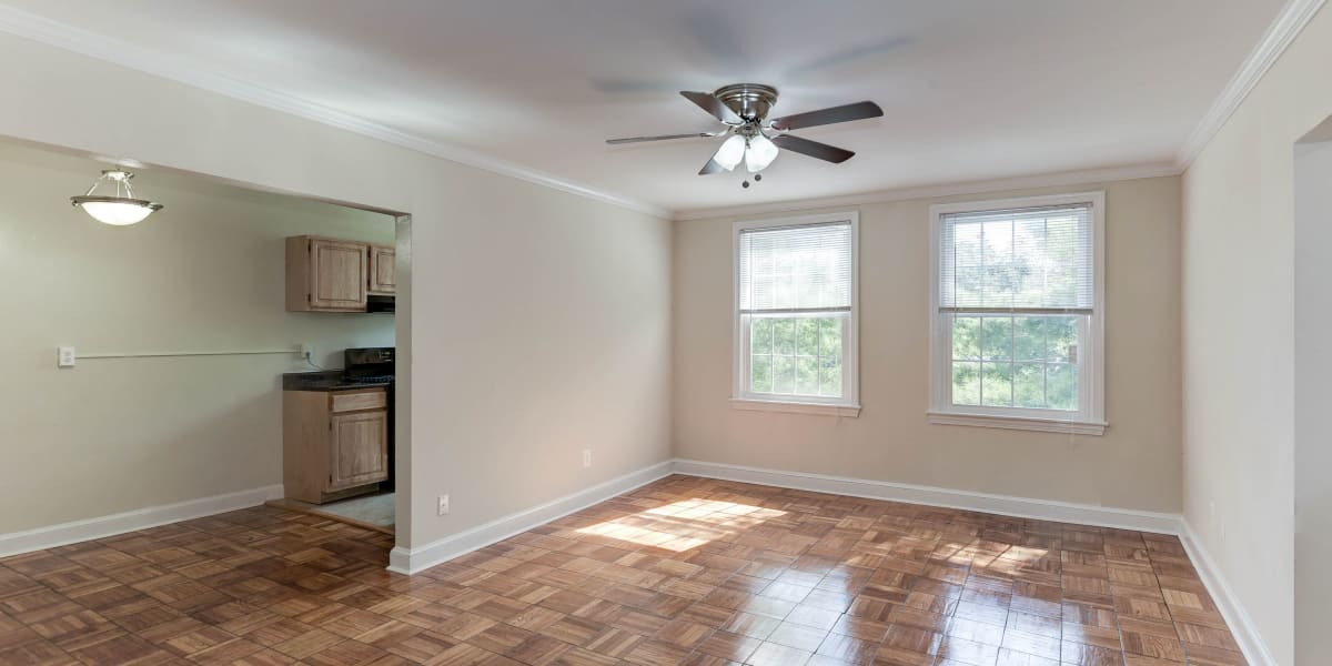 Empty apartment ready for move in with a ceiling fan and two windows in the living room at Chillum Manor in Washington, District of Columbia
