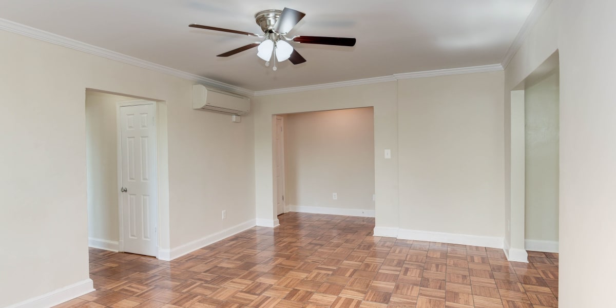 Spacious living area with wood style flooring and a fan at Chillum Manor in Washington, District of Columbia