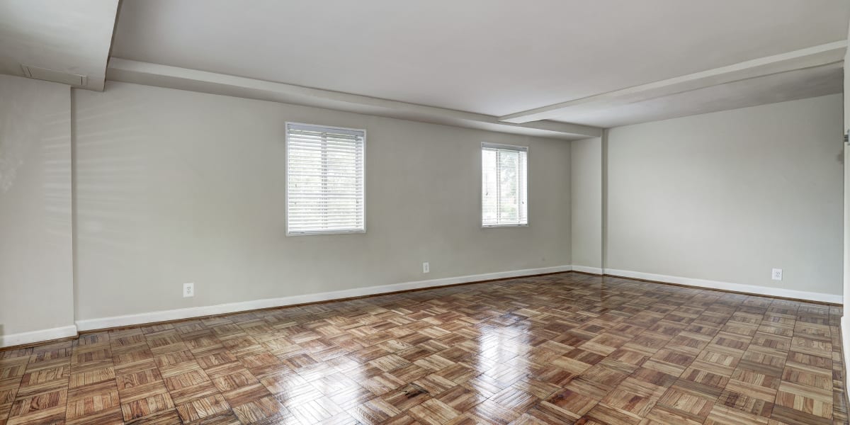 Unfurnished living room area with two windows and hardwood flooring at The Cromwell in Washington, District of Columbia
