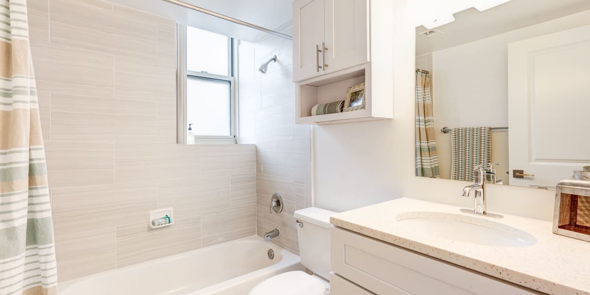 Cute bathroom with large mirror above the vanity at The Envoy Apartments in Washington, District of Columbia