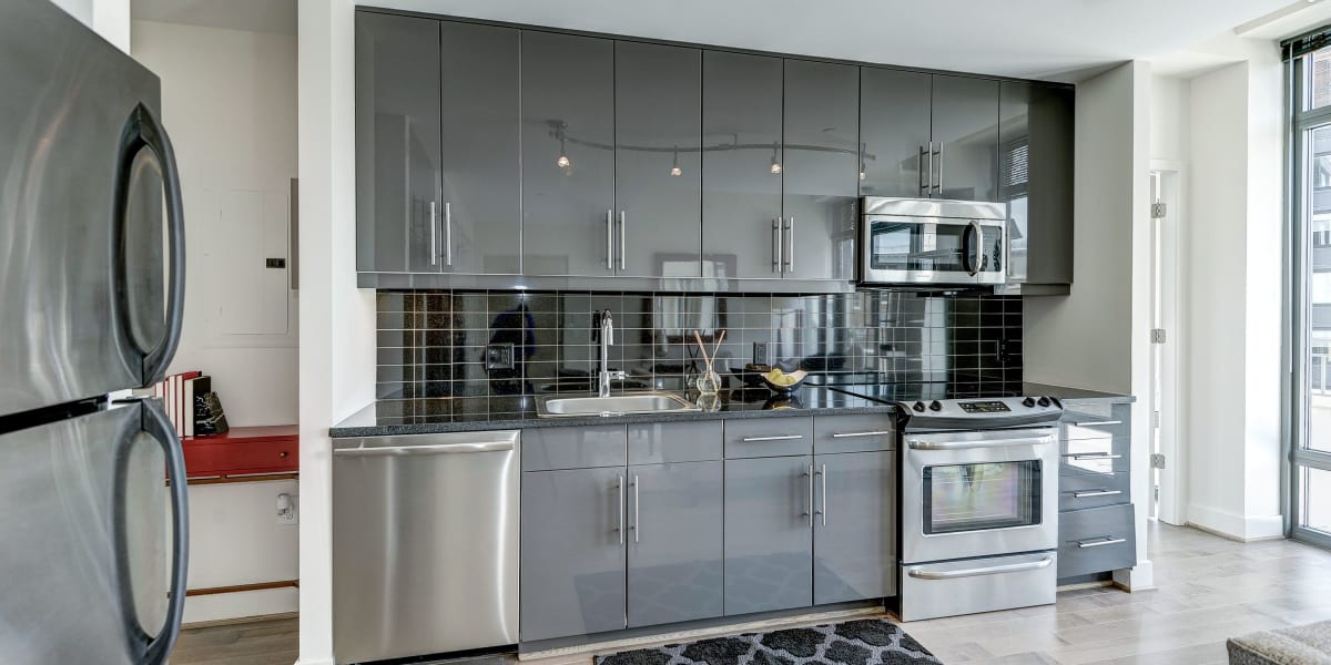 Incredible kitchen with cool grey cabinets and stainless steel appliances at The Bentley Apartments in Washington, District of Columbia