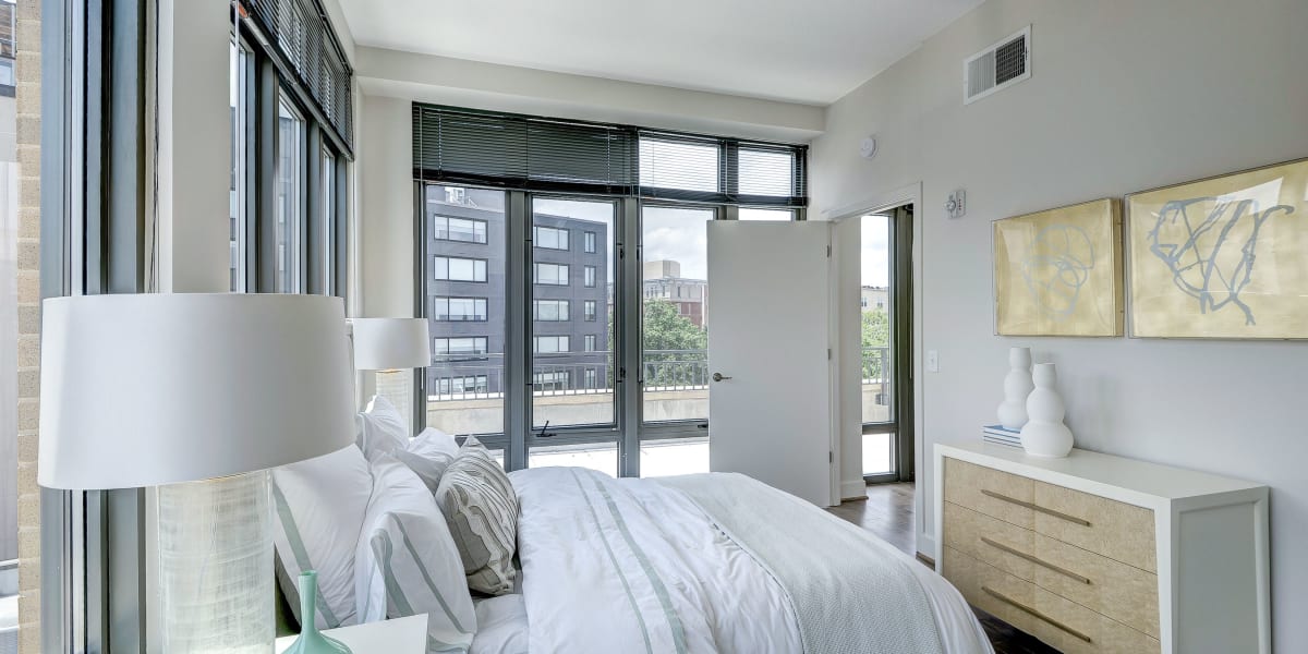 Nicely decorated bedroom with large windows and a nice view of the city at The Bentley Apartments in Washington, District of Columbia