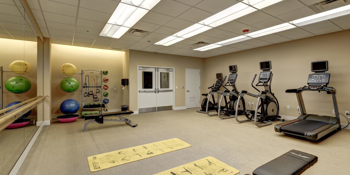 Cardio machines and free weights in the fitness center at The Bentley Apartments in Washington, District of Columbia