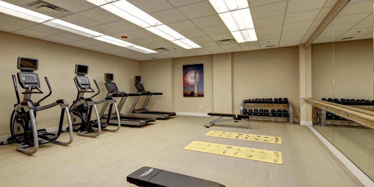 Resident fitness area with some cardio machines and an open space to stretch at The Bentley Apartments in Washington, District of Columbia