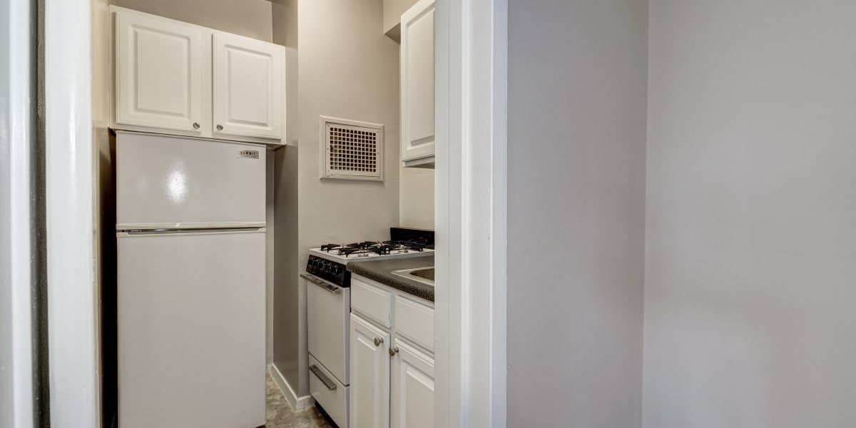 Cute kitchen with white cabinets and appliances at The Croydon in Washington, District of Columbia