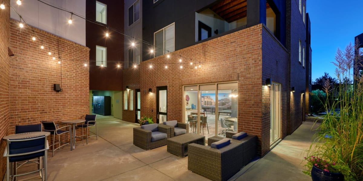 Outside lounge area with string lights hanging above at night at Marq Inverness in Englewood, Colorado