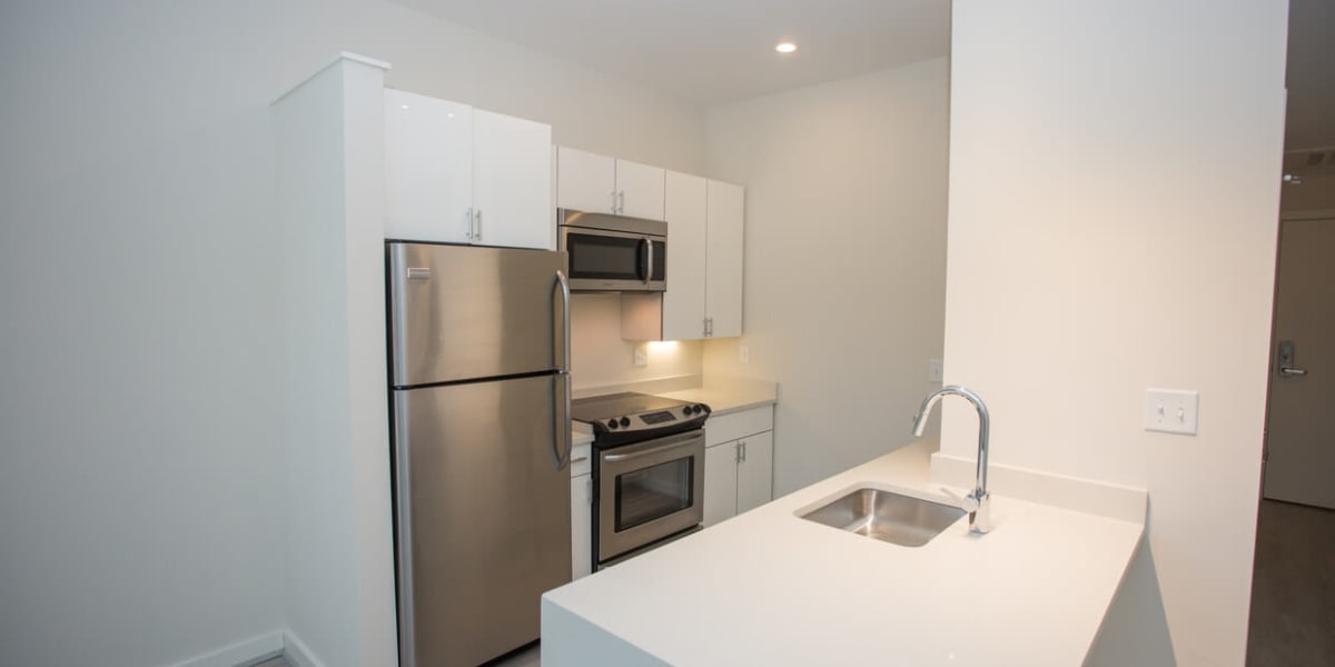 Sleek looking kitchen with a breakfast bar and all white counters at 3825 Georgia in Washington, District of Columbia