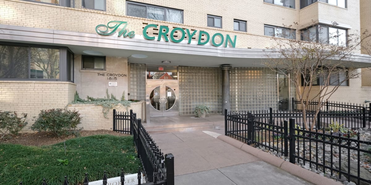 Exterior entrance with a nice black fence around grass at The Croydon in Washington, District of Columbia