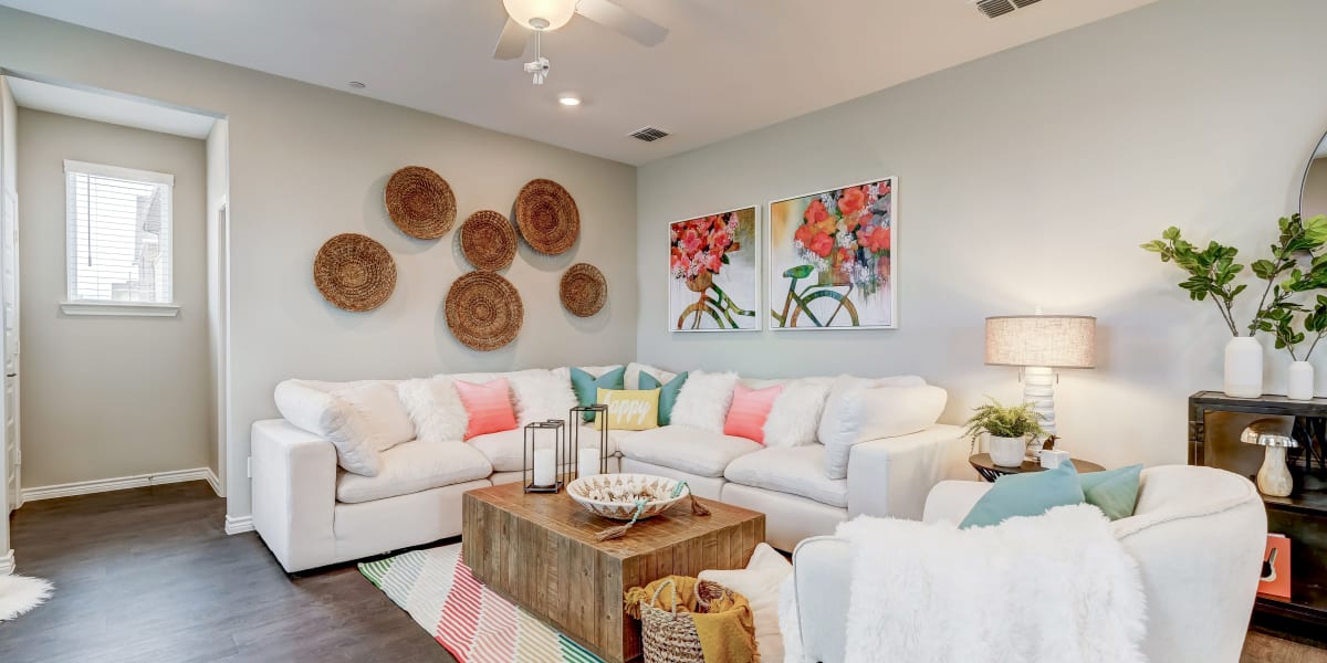 Spacious and well lit living room with a nice ceiling fan to stay cool in this model home at BB Living Light Farms in Celina, Texas