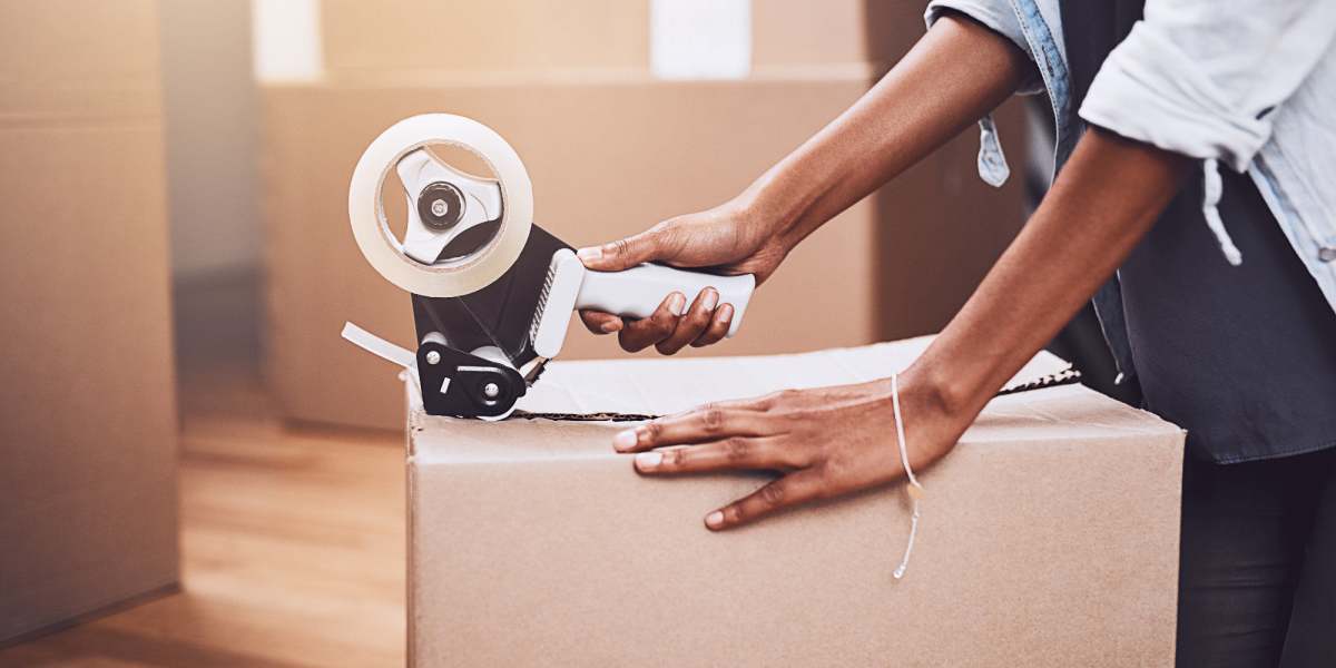 A person packing a box with tape at Storage Etc Koreatown in Los Angeles, California