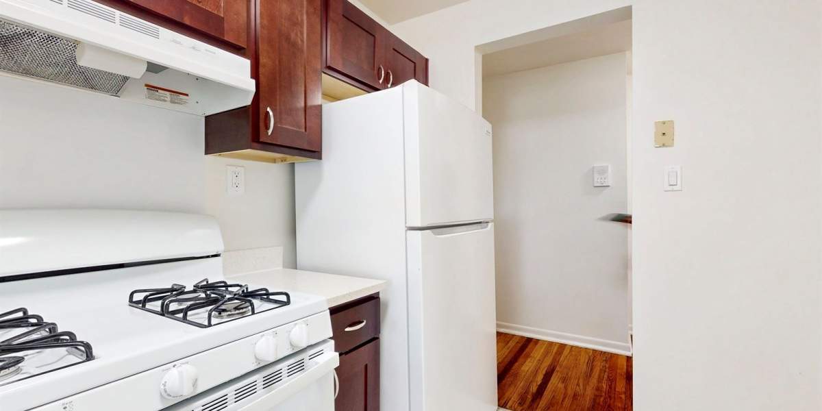 Well lit kitchen area with white appliances at Cherry Garden Apartments in Roselle, New Jersey