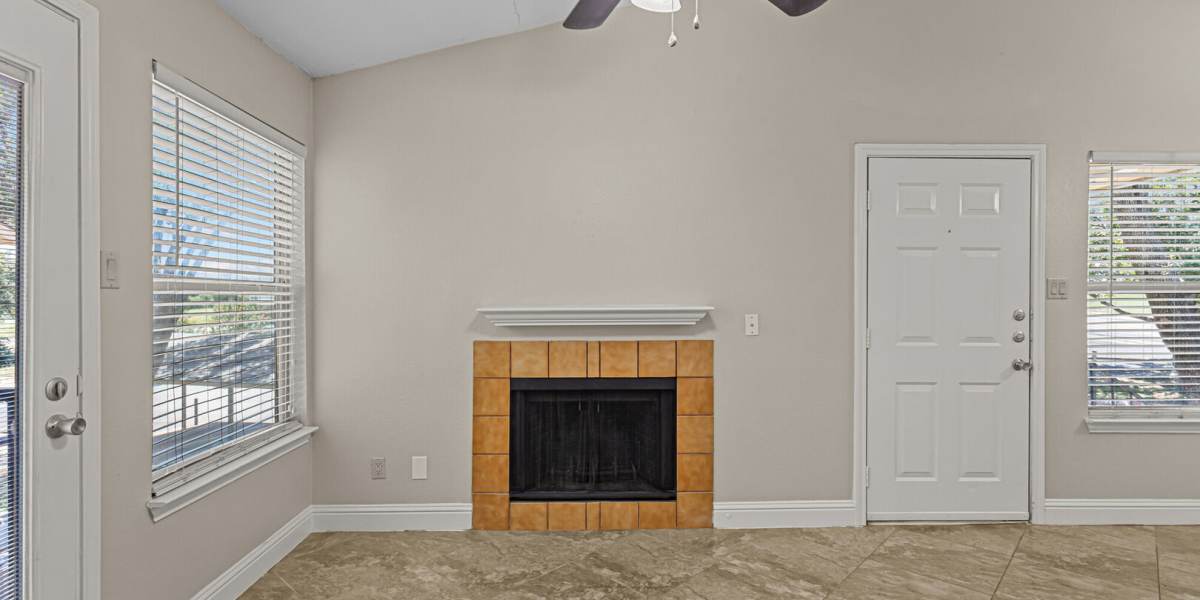 Living room looking at the fireplace and front door angle 2 at Courtyard Apartments And Storage in Granbury, Texas