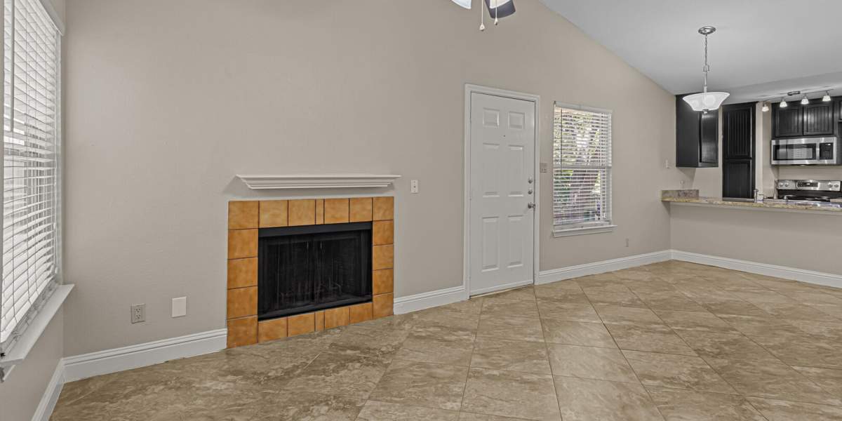 Living room looking at the fireplace and front door at Courtyard Apartments And Storage in Granbury, Texas