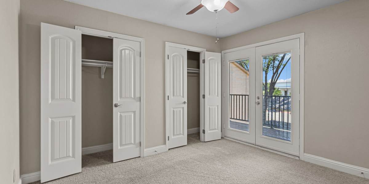 bedroom with 2 closets and a balcony at Courtyard Apartments And Storage in Granbury, Texas