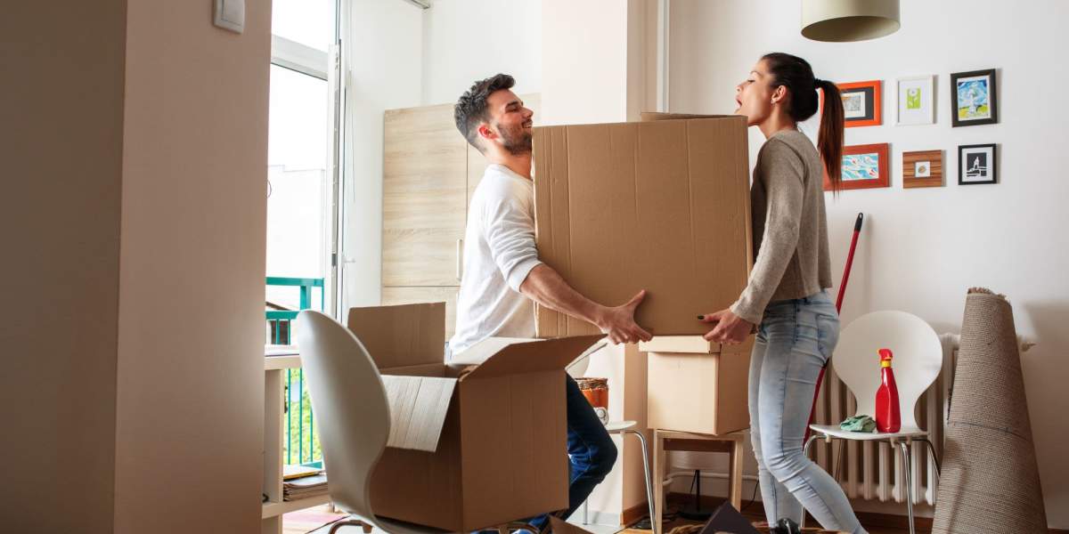 Couple carrying cardboard box at moving day at Mega Storage in Albany, Oregon