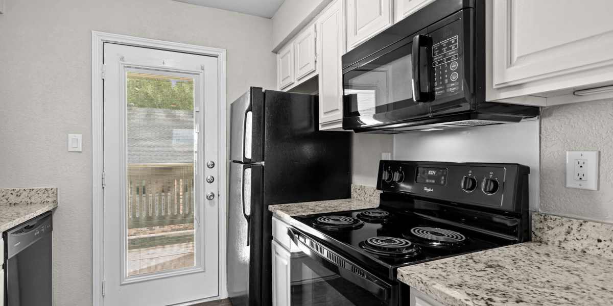 Apartment kitchen with black appliances at Towne Lake Apartments in Granbury, Texas
