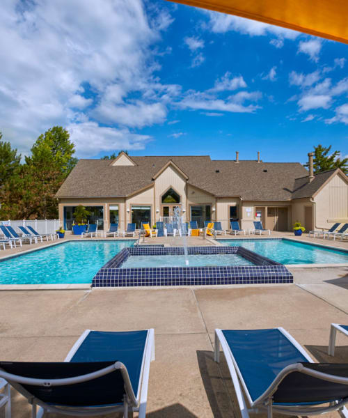 Lounge chairs by the sparkling swimming pool at Briar Cove Terrace Apartments in Ann Arbor, Michigan