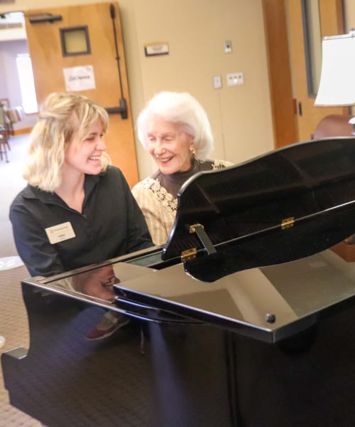 Resident and caregiver playing the piano at The Springs at Mill Creek in The Dalles, Oregon