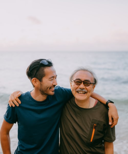 Happy resident having fun at beach with his son near Grand Villa Senior Living in Clearwater, Florida