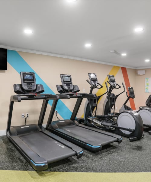 Treadmills and ellipticals in the fitness center at Kensington Manor Apartments in Farmington, Michigan