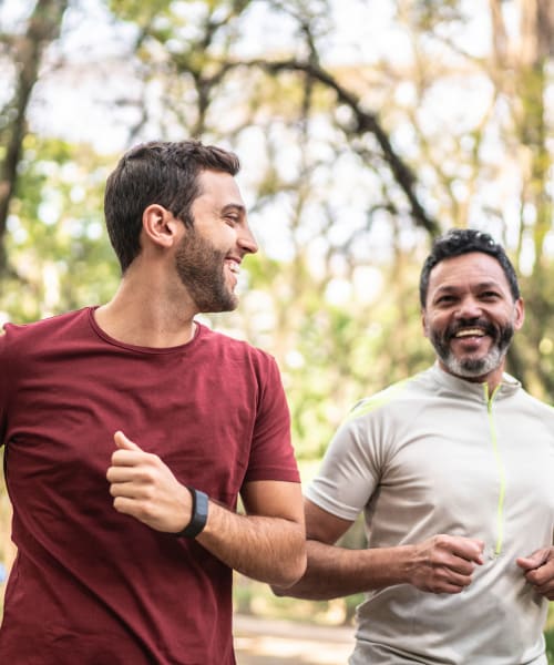Two men smiling while on a jog through a park near Kenilworth Inn in Asheville, North Carolina