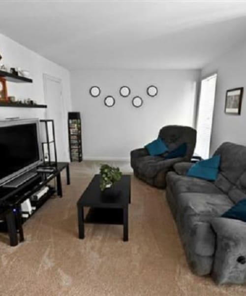 Apartment living room with a tv, couch and two chairs at Towne Crest in Gaithersburg, Maryland