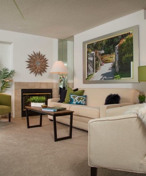 Living room with a gas fireplace and plush carpeting at Briar Cove Terrace Apartments in Ann Arbor, Michigan