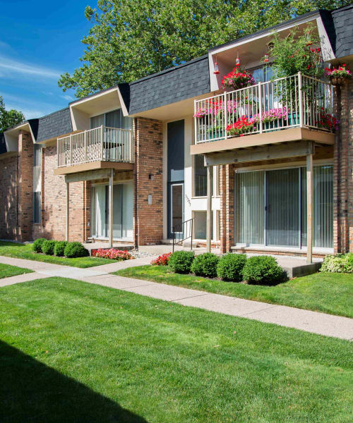Building with traditional architecture and private balconies at Kensington Manor Apartments in Farmington, Michigan