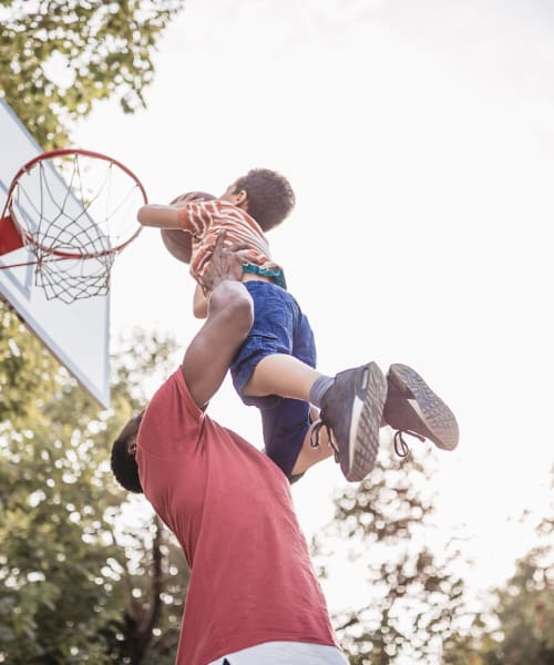 A kid with his father playing basketball at Canyon Manor in American Canyon, California