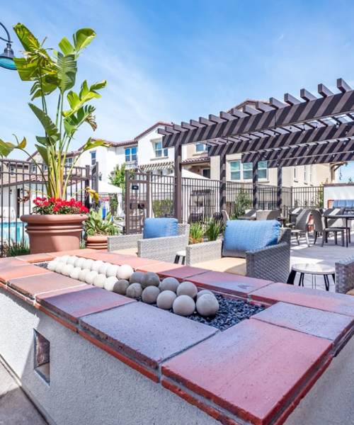 Covered outdoor BBQ area with seating at Ageno Apartments in Livermore, California
