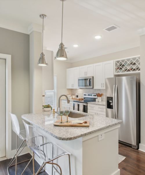 Model kitchen with white cabinetry and stainless-steel appliances at Somerset in McDonough, Georgia