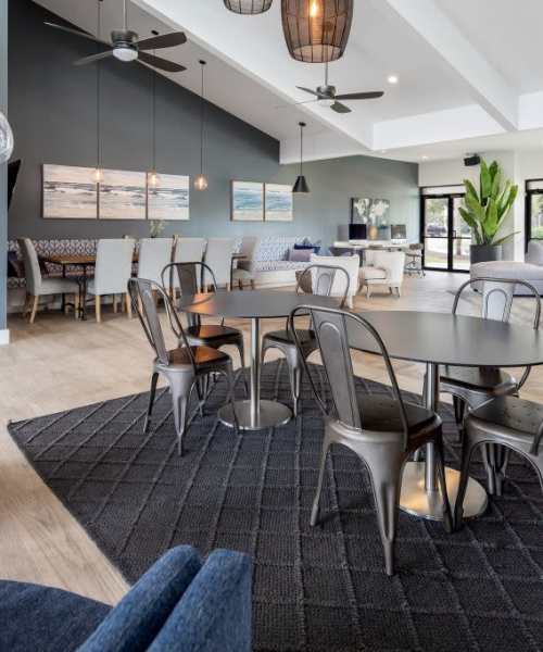 Tables and chairs in the community clubhouse at The Seven At West Boca in Boca Raton, Florida