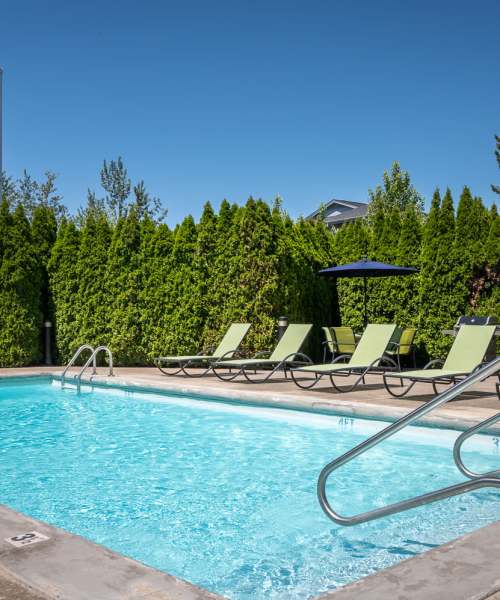 Outdoor Pool with Sun Loungers at Chinook Way Apartments in Fairview, Oregon