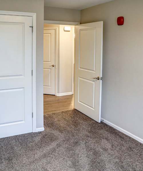 Carpeted living space with open layout and two doorways leading to additional rooms at Tristan Ridge in Eminence, Kentucky
