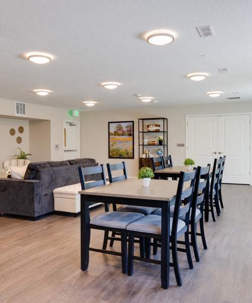 Community lounge with dining area and modern furnishings at Williams Terrace in Indianola, Iowa