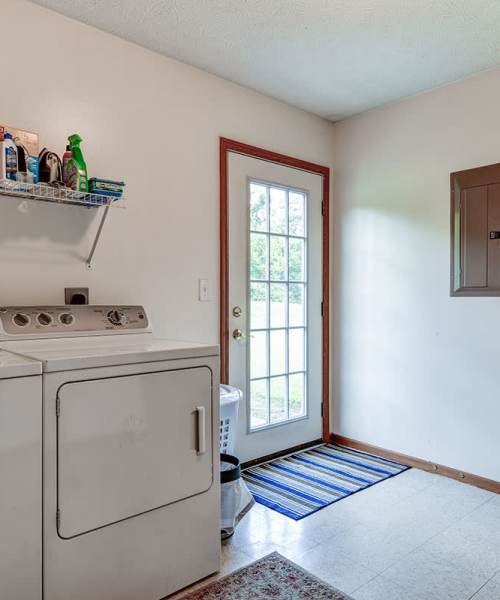 Laundry area with washer and door to outside at Chartwell Greene in Mount Gilead, Ohio