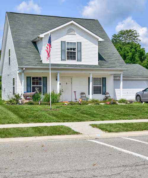 White siding home with American flag at Chartwell Greene in Mount Gilead, Ohio