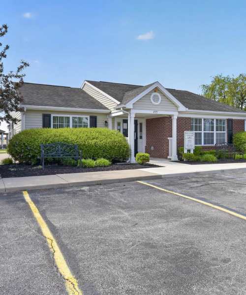 Clubhouse entrance with landscaped greenery at Lake Towne Senior in Walbridge, Ohio