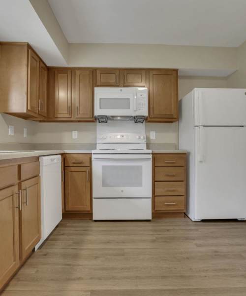 Kitchen with granite countertops and wood-style flooring at Plumly Townhomes in Barnesville, Ohio