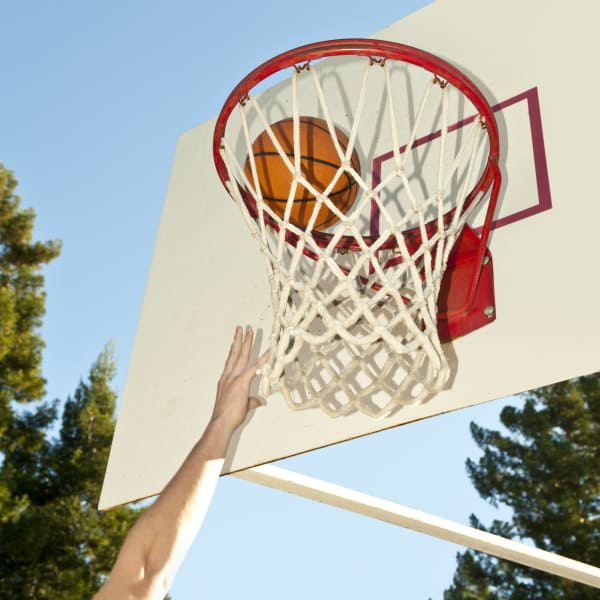 Resident playing basketball on a beautiful day at Pine Tree Apartments in Chico, California
