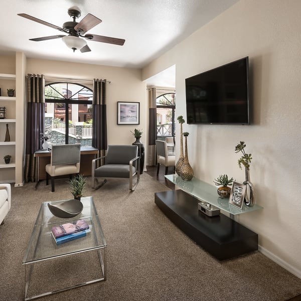 Living room with a ceiling fan in model home at San Lagos in Glendale, Arizona