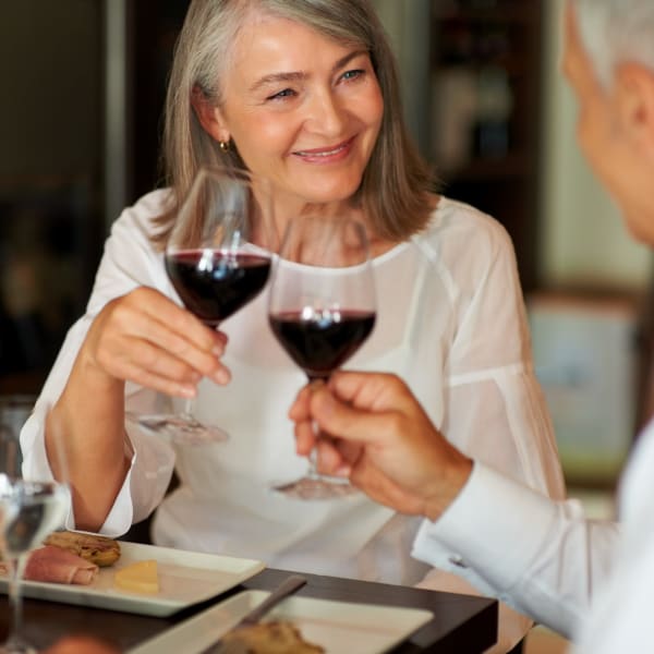 Resident couple toasting over wine at Quail Park at Browns Point in Tacoma, Washington
