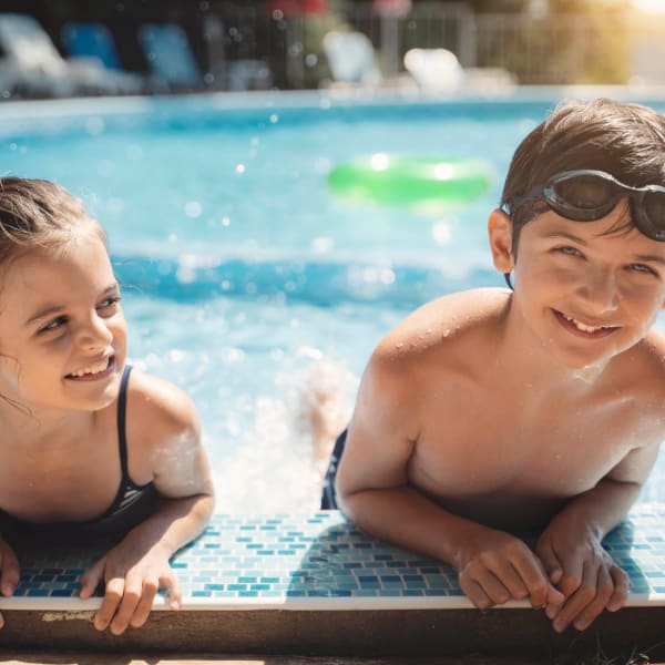 Brother and sister having a ball at the pool at El Potrero Apartments in Bakersfield, California